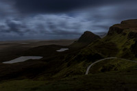 The curves of the Quiraing under a cloudy full moon sky.